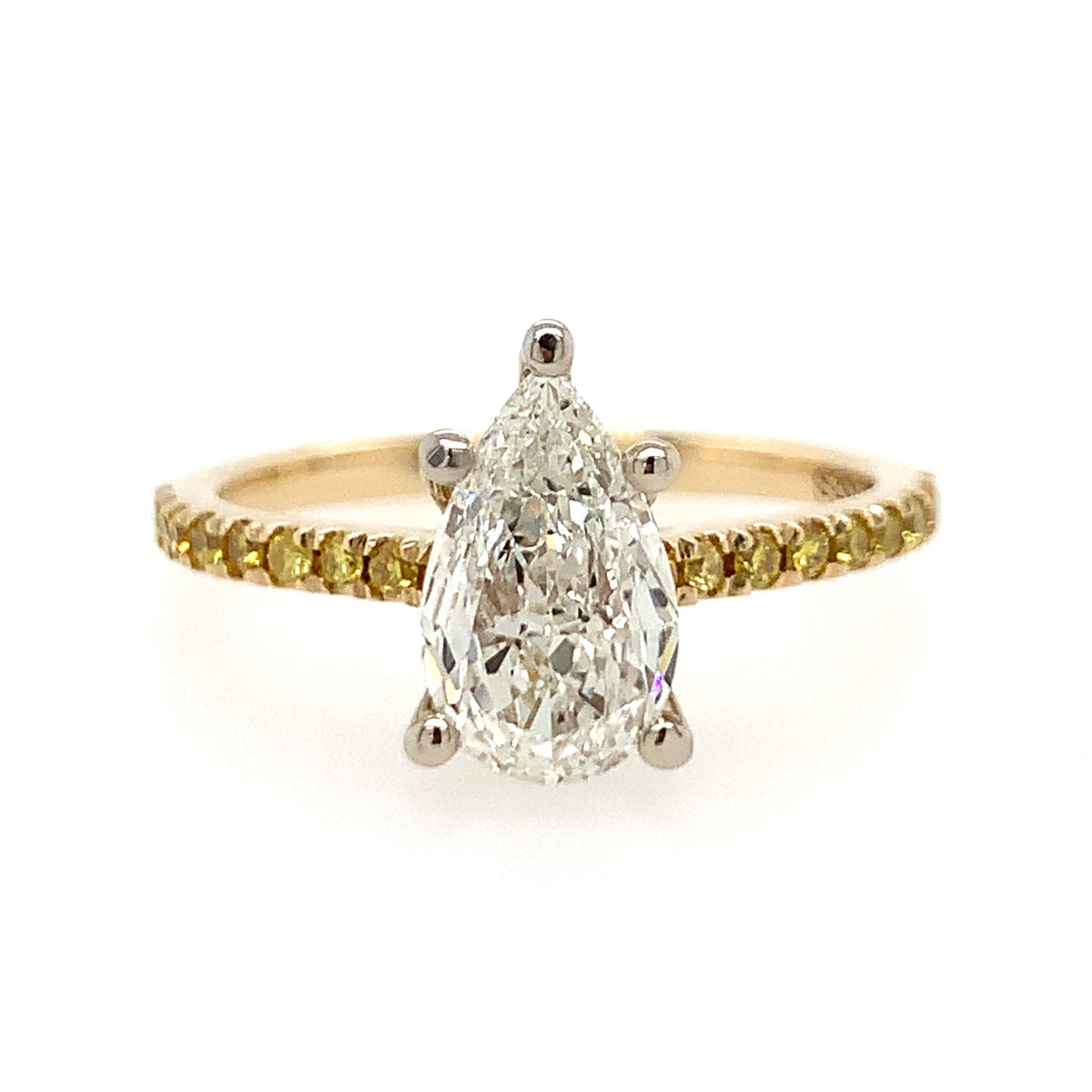 Gold ring with a pear-shaped diamond on a white background