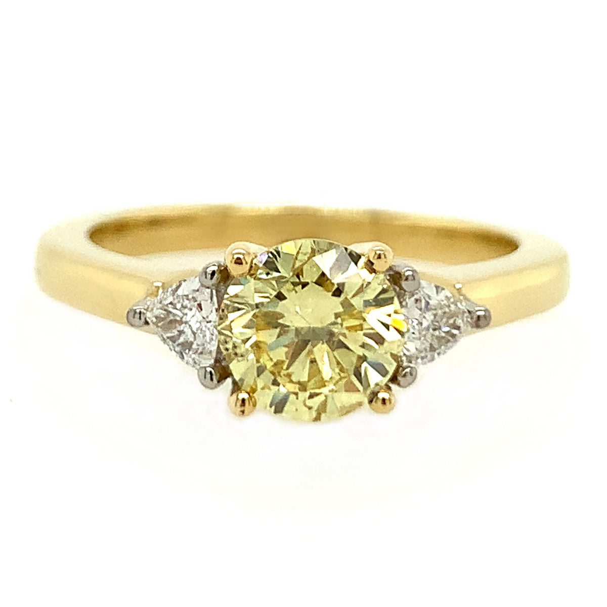 Gold ring with a yellow gemstone and two smaller diamonds on a white background
