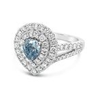 Diamond ring with a pear-shaped blue gemstone on a white background