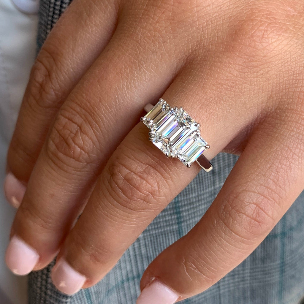 Diamond ring on a finger with a neutral background