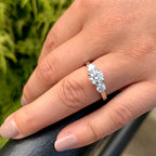 Diamond ring on a finger with a blurred green background