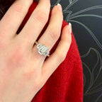 Hand wearing a silver ring with a red fabric background