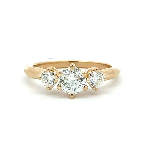 Gold ring with three diamonds on a white background