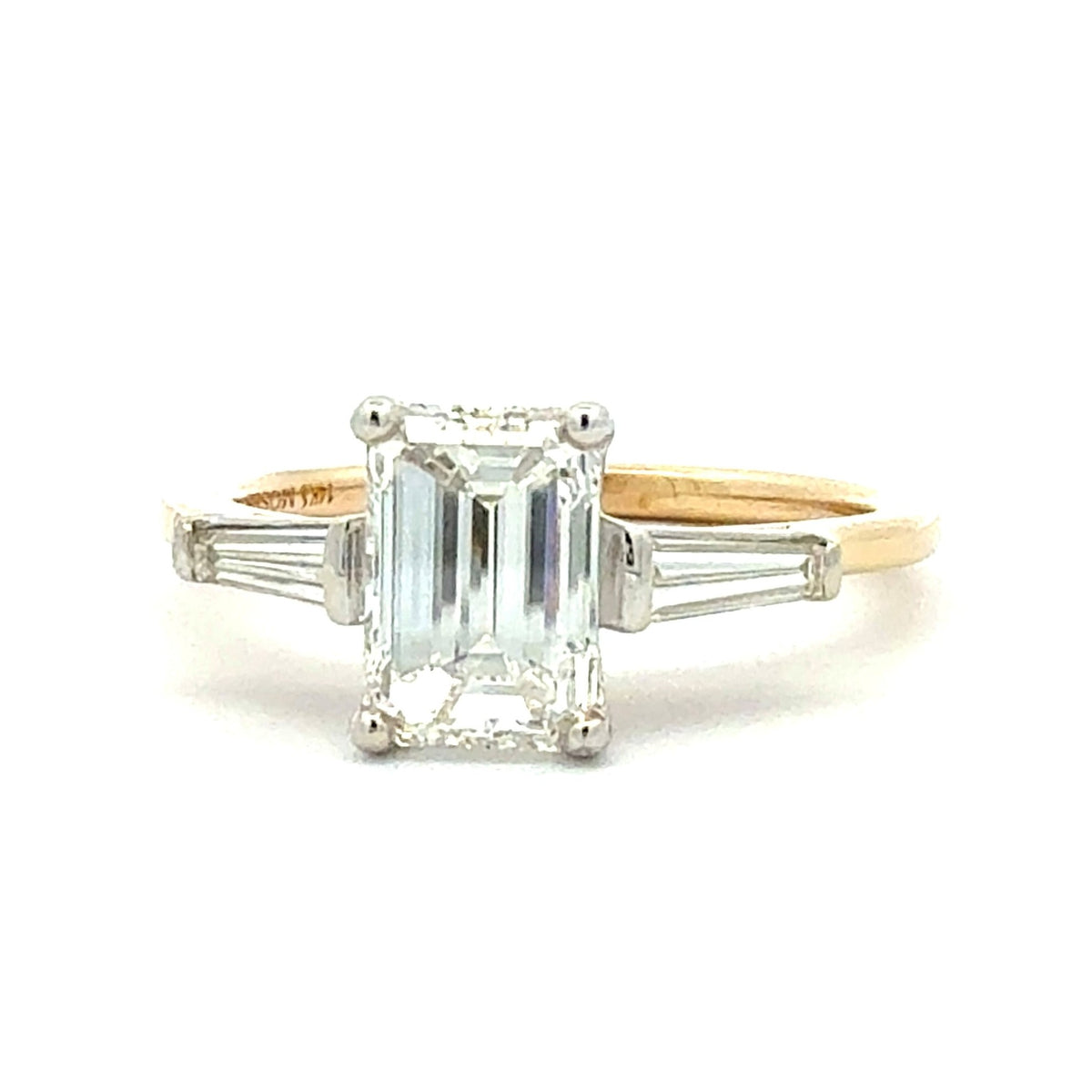 Gold and silver ring with a large central gemstone on a white background
