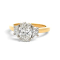 A yellow gold ring featuring a pear-cut center diamond surrounded by two smaller round diamonds, set in a silver-colored prong setting on a polished gold band, shown against a plain white background.