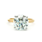 A classic solitaire engagement ring featuring a round brilliant-cut diamond set in a yellow gold band with a silver-colored prong setting, shown on a plain white background.
