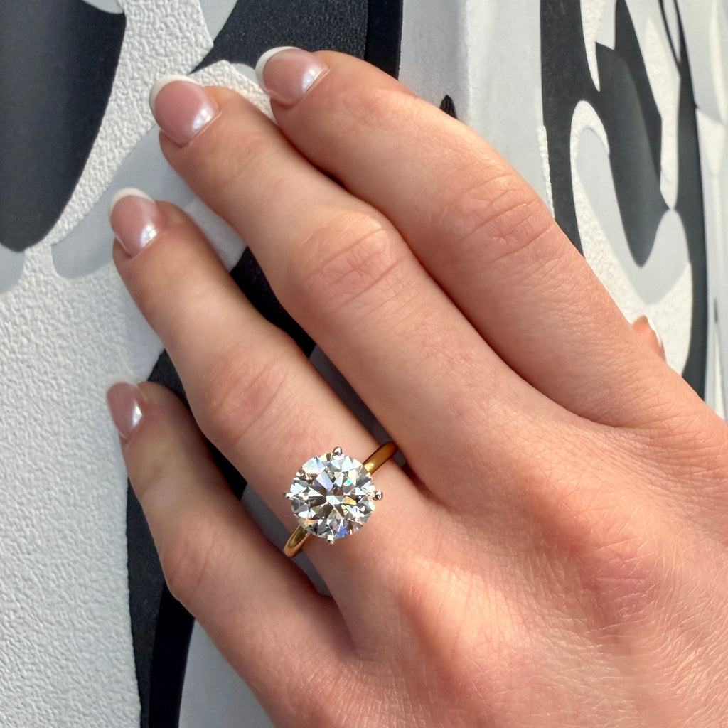 Hand wearing a diamond ring with a blurred background