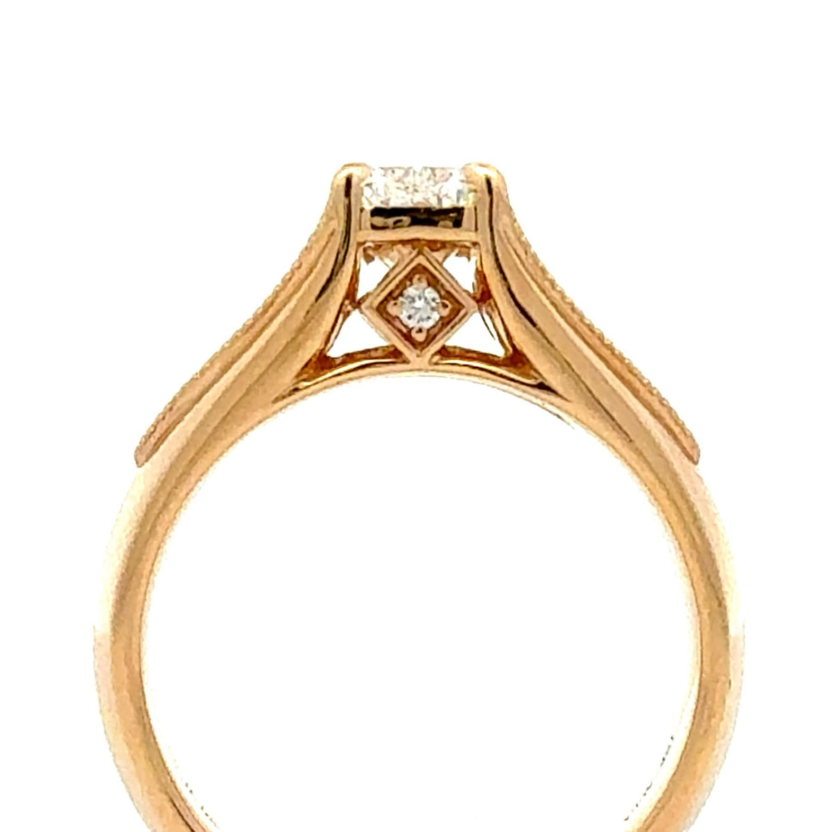 A close-up shot of a yellow gold ring featuring a diamond solitaire and a small diamond accent in a diamond-shaped setting, on a plain white background.