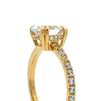 A close-up shot of a yellow gold ring featuring a large rectangular clear gemstone in a prong setting, with smaller diamonds along the band, set against a plain white background.