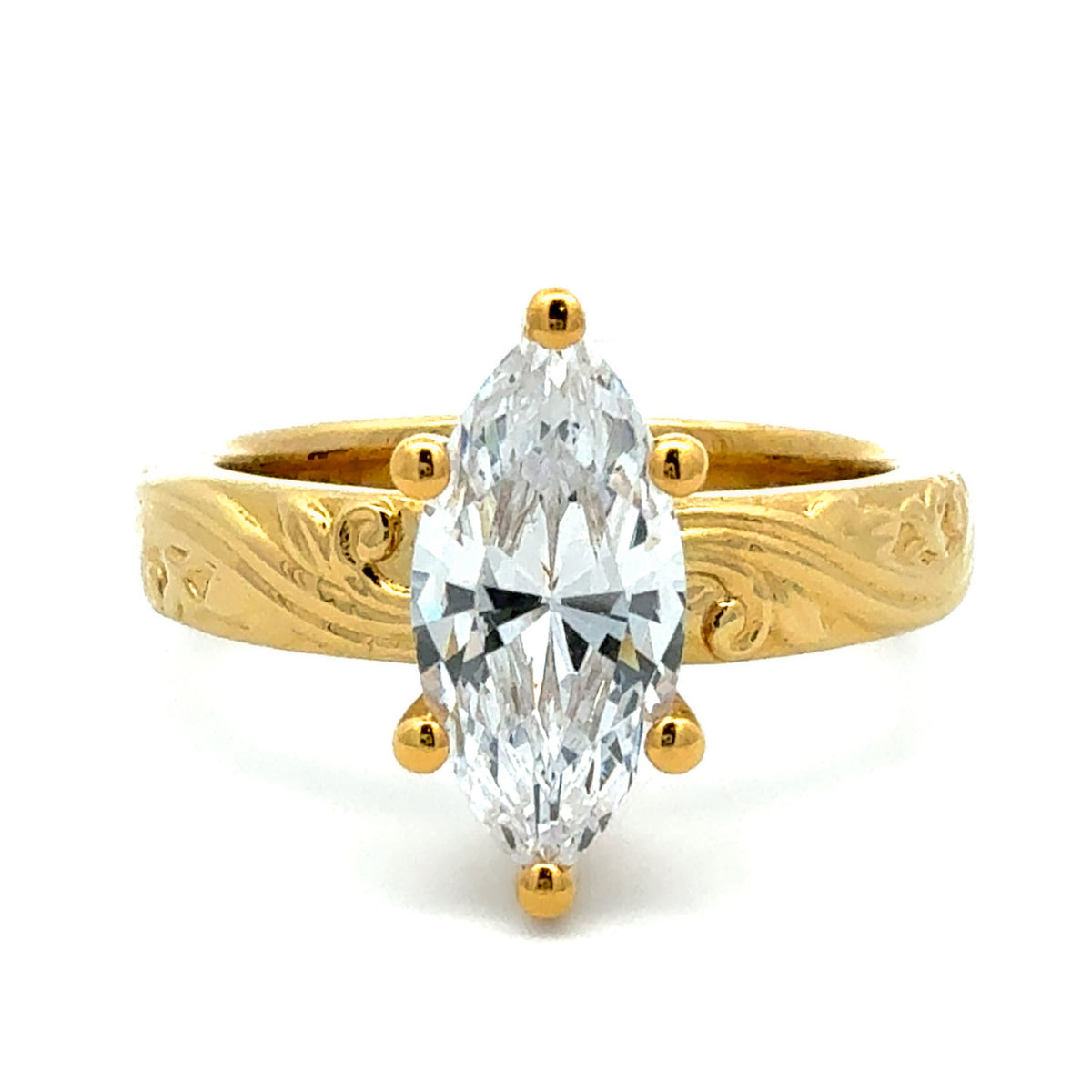 A yellow gold ring featuring a large marquise-cut clear gemstone in a six-prong setting, with an engraved band, shown on a white background.