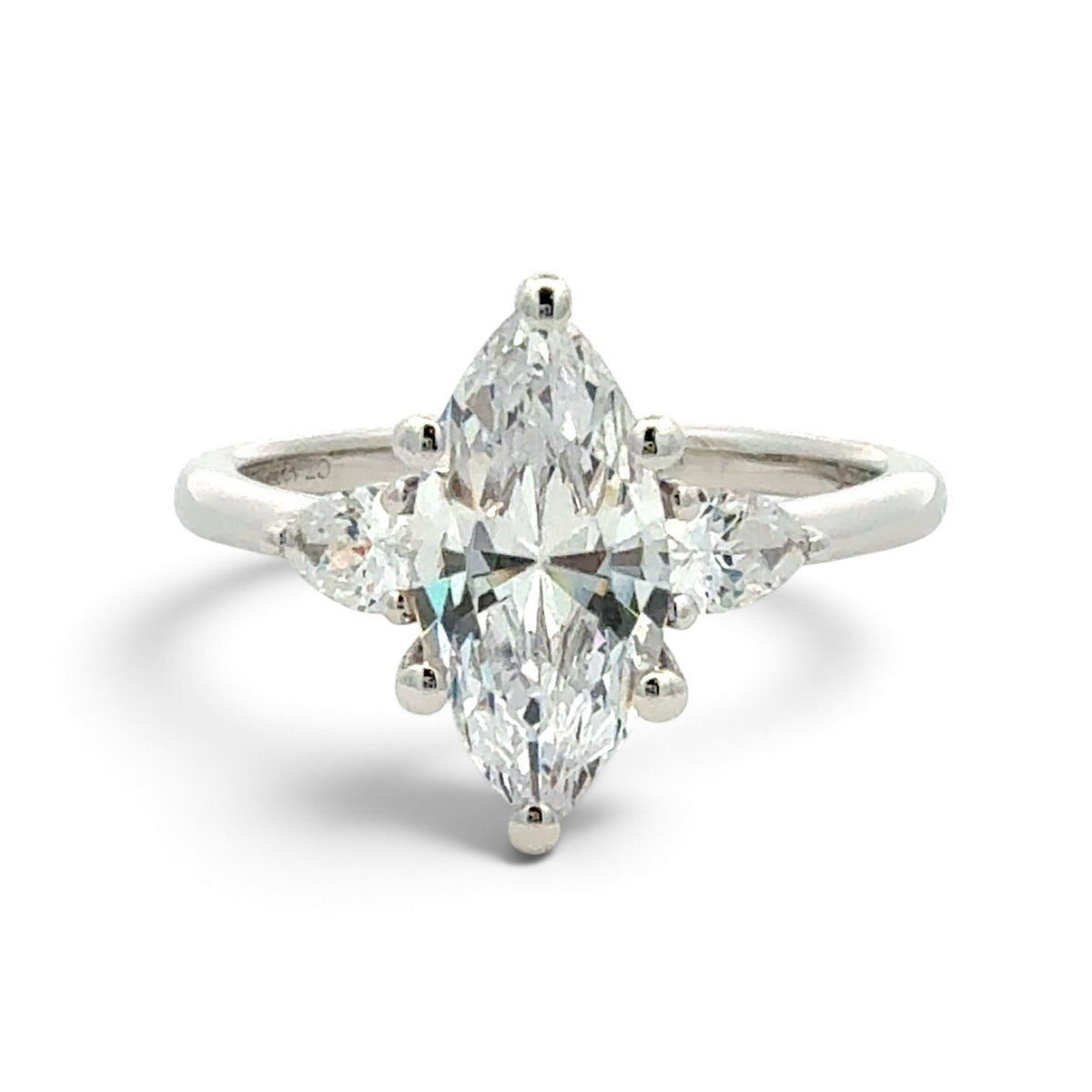 A silver ring featuring a large marquise-cut diamond in a four-prong setting, flanked by smaller round and marquise-cut diamonds on a clean white background.