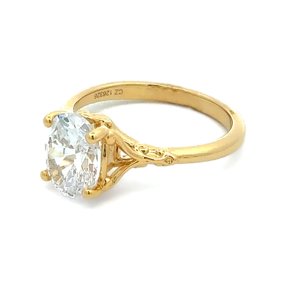A yellow gold solitaire ring featuring an oval-cut clear gemstone in a four-prong setting, shown on a plain white background. The inside of the band is engraved with 'CZ 1.