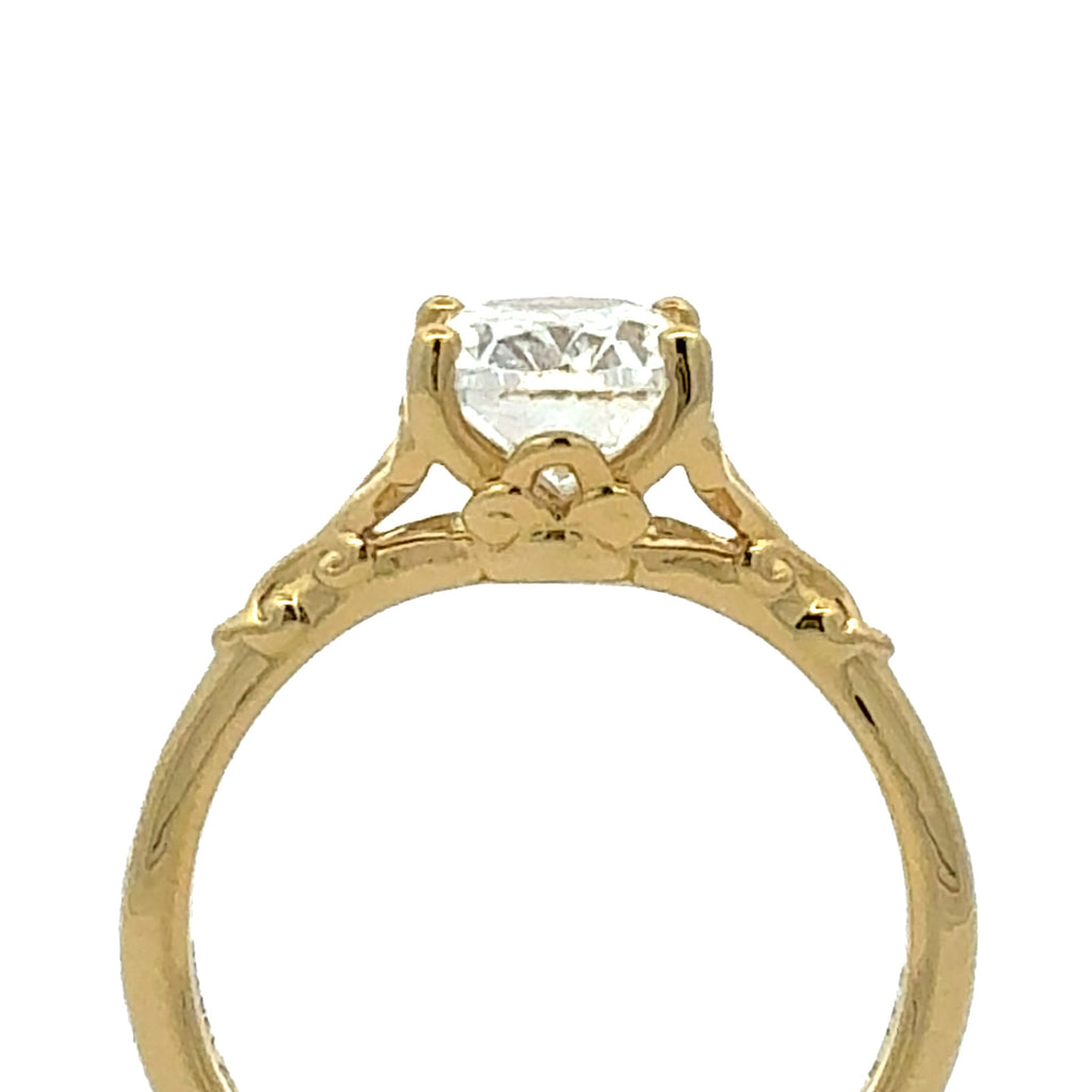 A yellow gold solitaire engagement ring with a round brilliant-cut clear gemstone, shown against a plain white background.