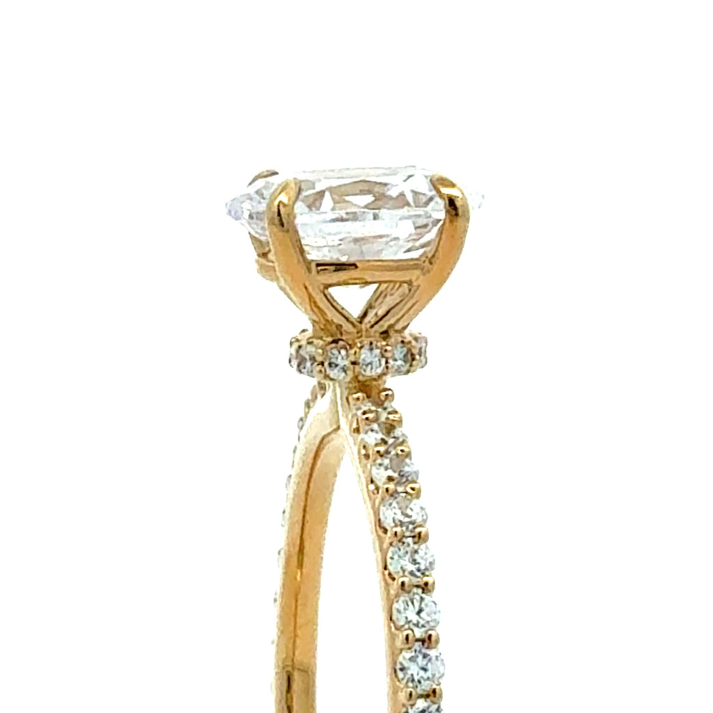 A close-up of a yellow gold ring featuring a large oval-cut clear gemstone in a prong setting, with small accent stones along the band, shown against a plain white background.