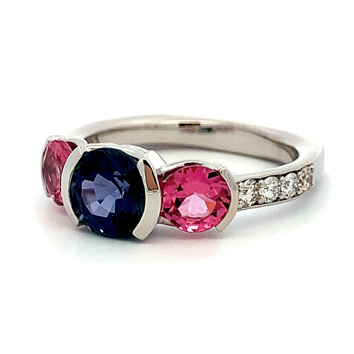 Silver ring with pink and blue gemstones on a white background