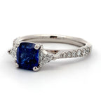 Ring with a blue gemstone and diamond accents on a white background
