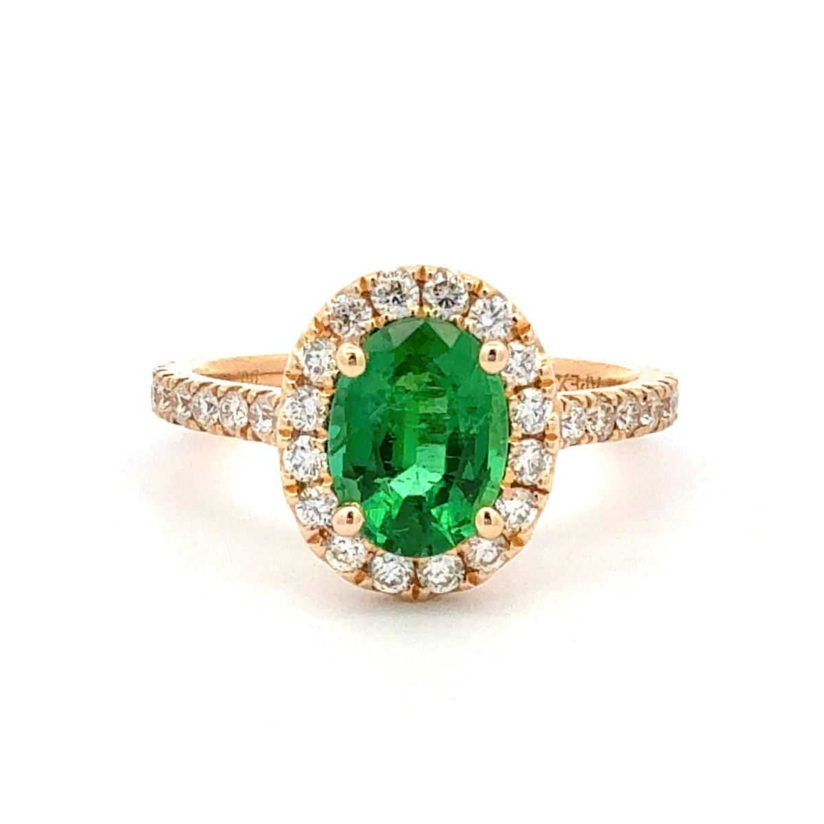 A yellow gold ring featuring a large oval-cut green emerald gemstone surrounded by a halo of small clear stones, with the band also paved with clear stones, set against a plain white background.
