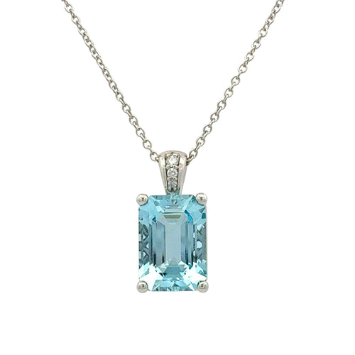 A silver pendant necklace featuring an emerald-cut light blue topaz gemstone in a four-prong setting, with a small pavé diamond accent on the bail, shown against a plain white background.