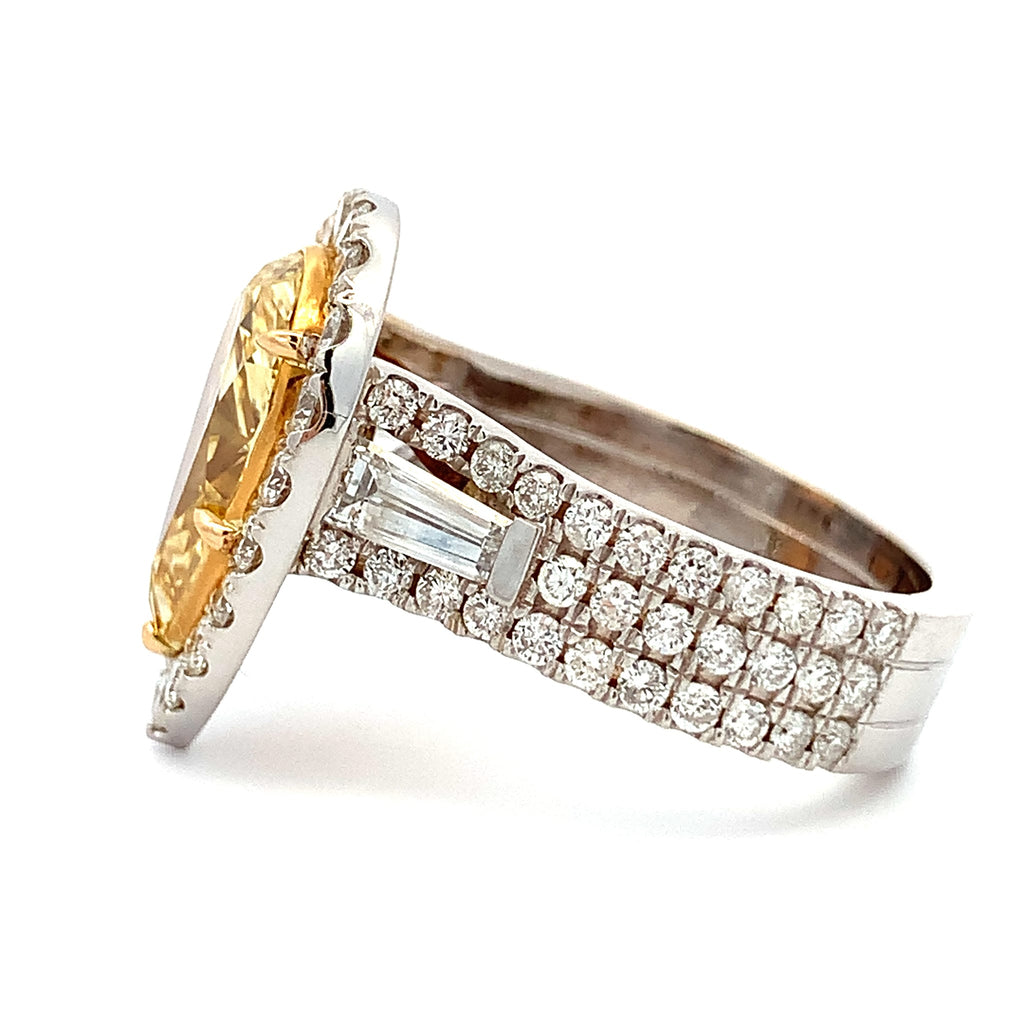 Gold and silver ring with gemstone and diamond accents on a white background