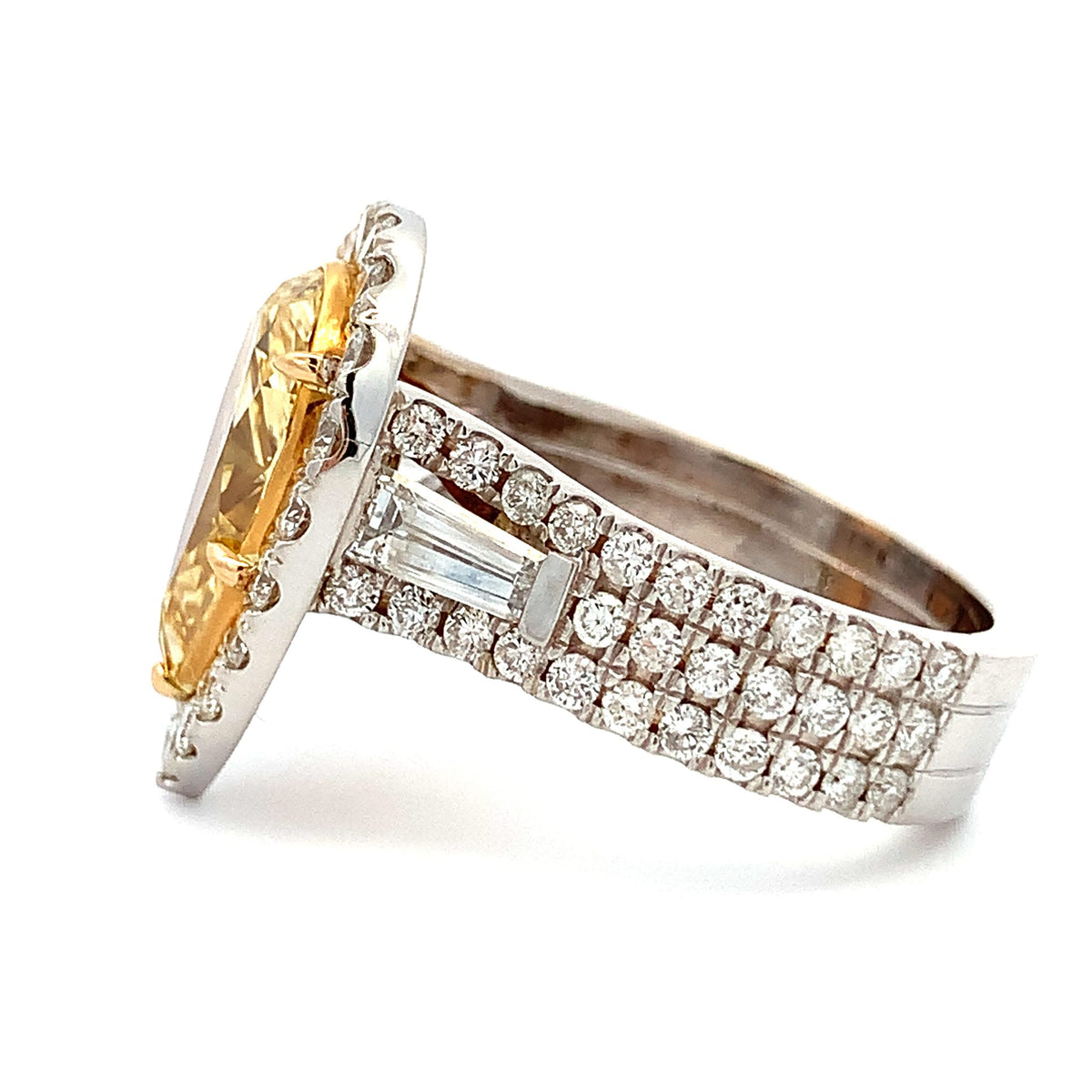 Gold and silver ring with gemstone and diamond accents on a white background