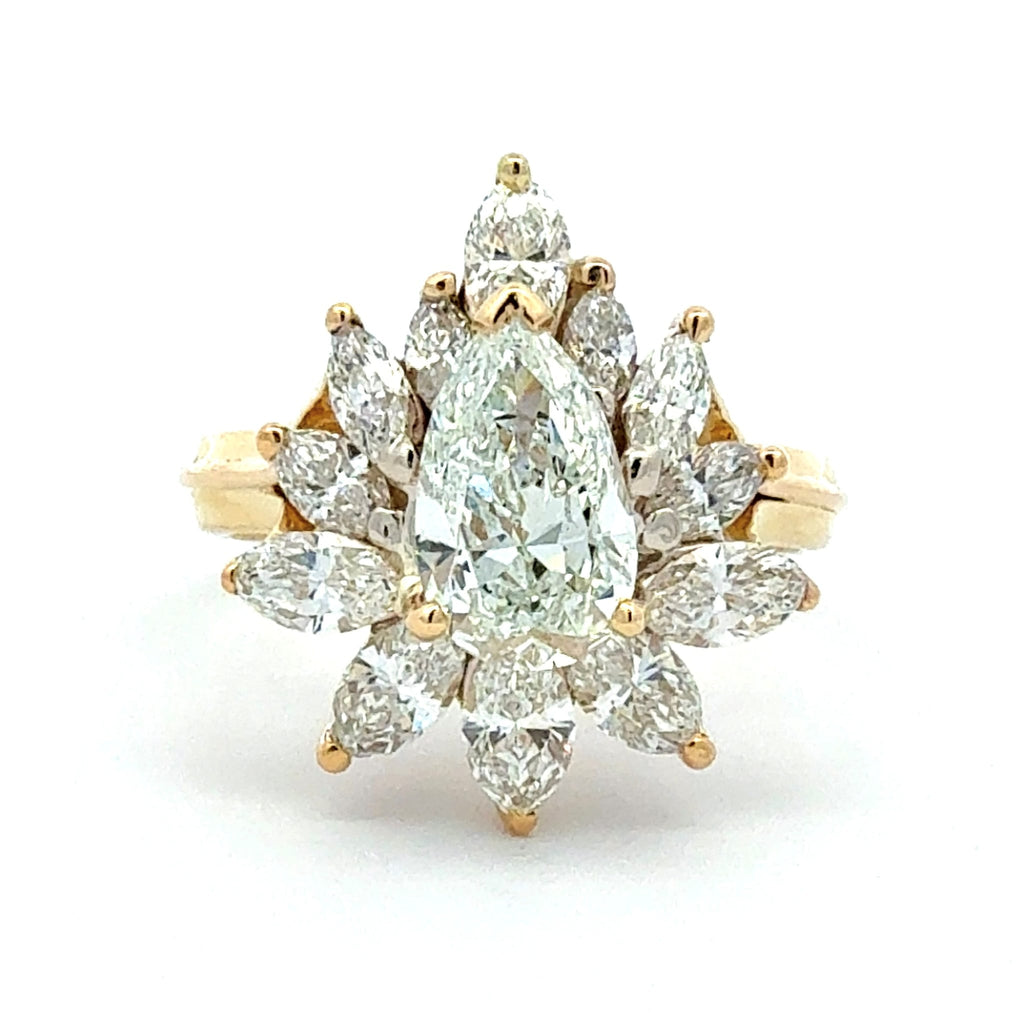 Gold ring with pear-shaped diamonds on a white background
