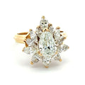 Gold ring with a central green gemstone and diamond accents on a white background