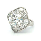 Diamond ring with a large central gemstone and smaller stones on a white background
