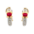 A pair of gold and white gold huggie hoop earrings with round-cut red ruby centers and a channel of small clear cubic zirconia stones on the lower curve, shown against a plain white background.