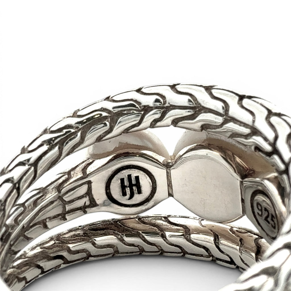 A close-up of a silver braided chain bracelet showing the interior clasp mechanism, featuring a circular medallion with an 'HH' logo and a '925' sterling silver stamp, on a white background.