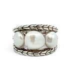 A silver ring featuring three large, lustrous white baroque pearls set in a braided, textured sterling silver band, photographed on a clean white background.