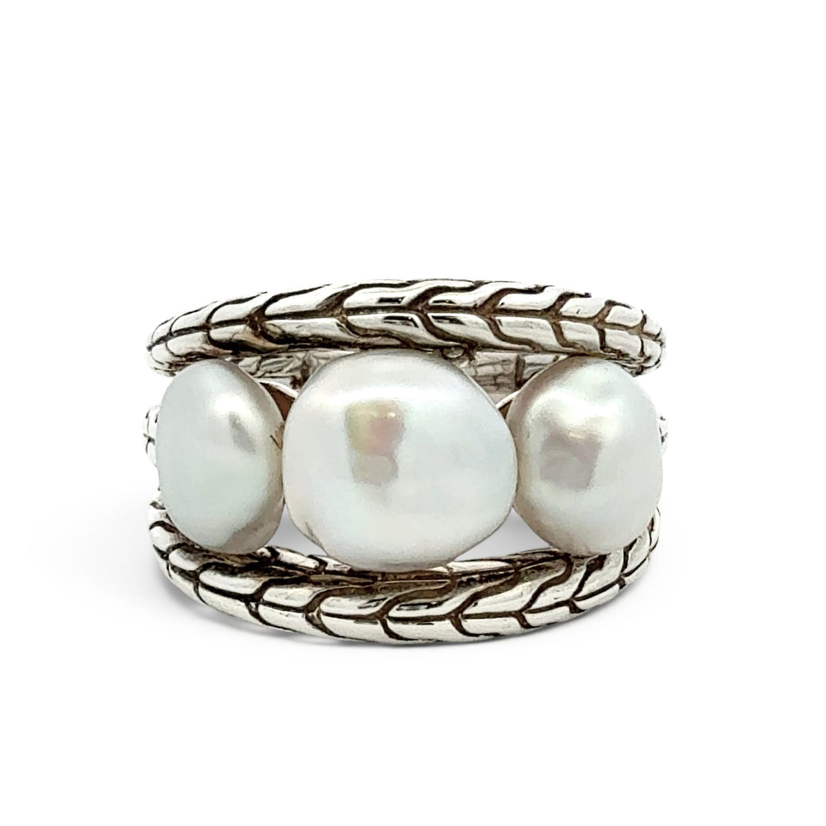 A silver ring featuring three large, lustrous white baroque pearls set in a braided, textured sterling silver band, photographed on a clean white background.