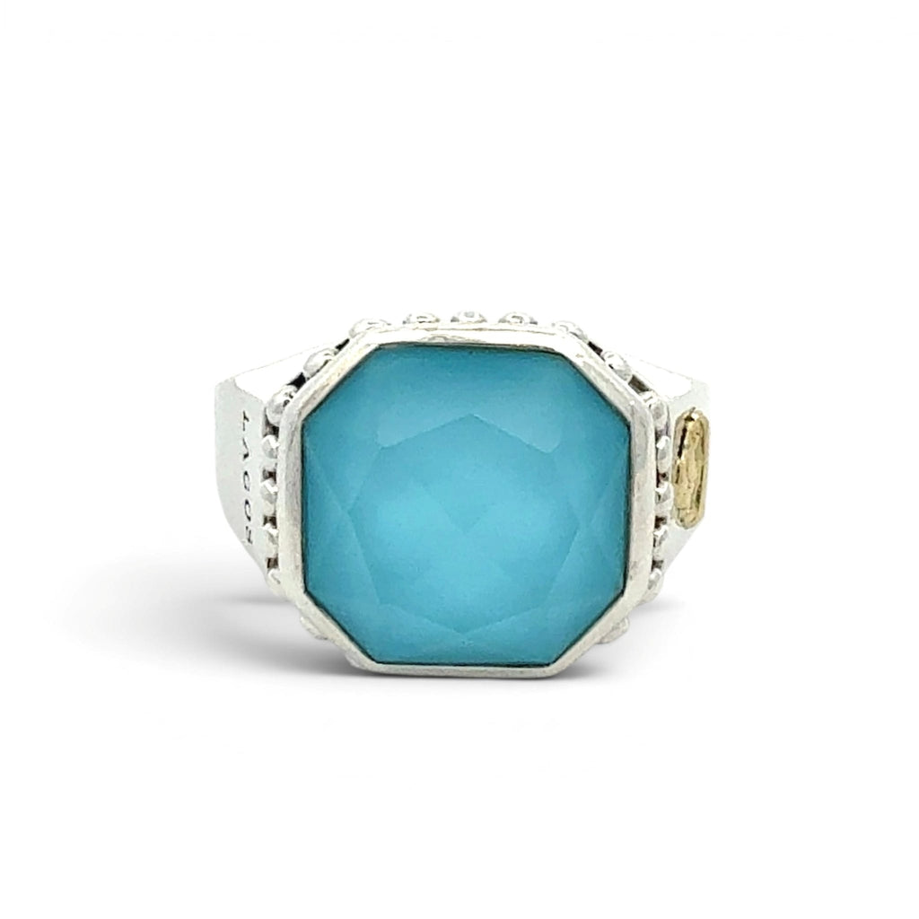 A silver-toned octagonal signet ring featuring a large, faceted light blue turquoise center stone, accented with small clear stones along the shoulders and a small gold-toned detail on the band, set against a plain white background.