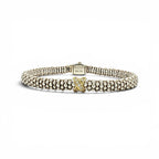 A Lacoste beaded bracelet in silver-tone metal with a central yellow gold 'L' accent, displayed on a clean white background.