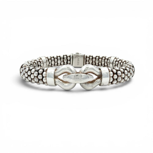 A silver-toned beaded bracelet with a central knot-like clasp and a small engraved brand tag reading 'LACOT' on the inside, shown on a clean white background.