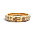 A polished yellow gold bangle bracelet with a distinctive ribbed, snake-like segmented exterior, shown on a clean white background.