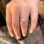 Close-up of a hand wearing a diamond ring with a blurred background