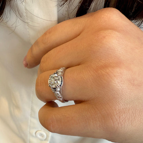 Close-up of a hand wearing a diamond ring with a blurred background