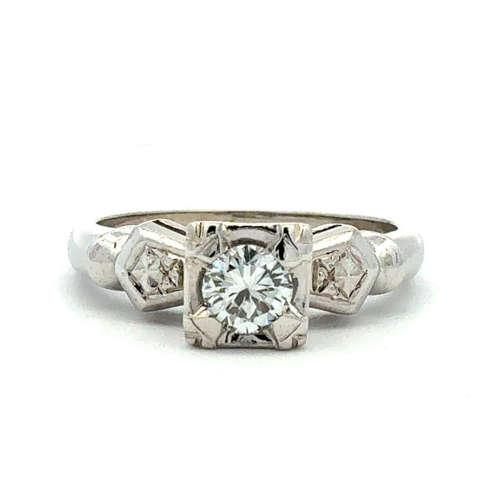 Silver ring with a central diamond and smaller diamonds on a white background