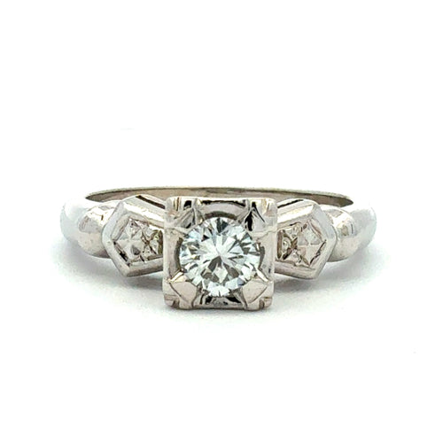 Silver ring with a central diamond and smaller diamonds on a white background