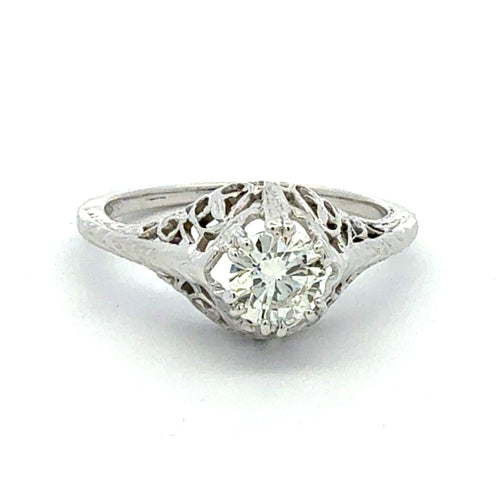 Diamond ring with intricate filigree design on a white background