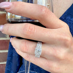 Hand wearing a diamond ring holding a glass of red wine.
