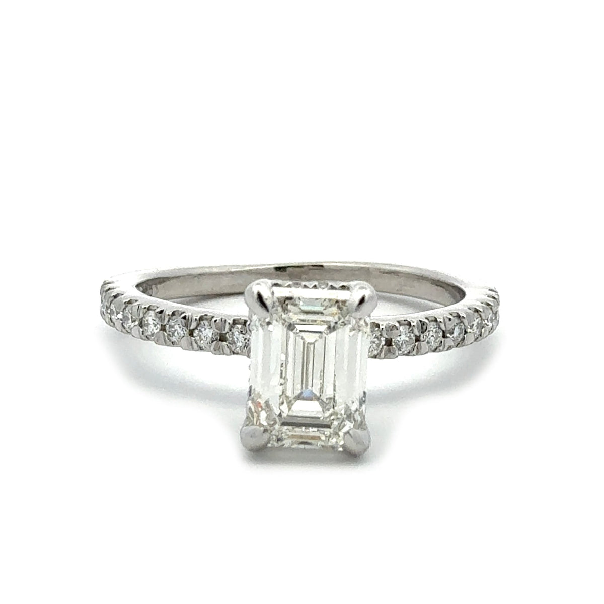 Diamond ring with emerald-cut center stone on a white background