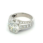 Diamond ring with a large central gemstone and smaller stones on a white background