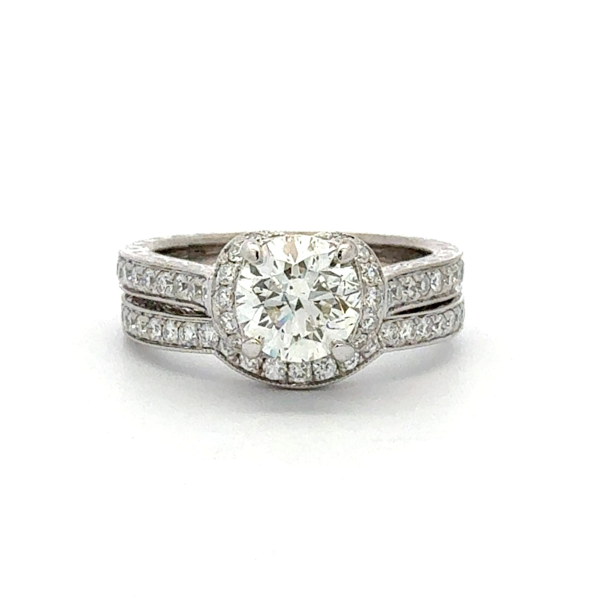A silver-toned double-band ring set with a large round-cut center stone and smaller pavé stones along the band, shown on a plain white background.