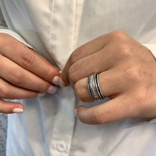 Close-up of hands with a ring buttoning a white shirt