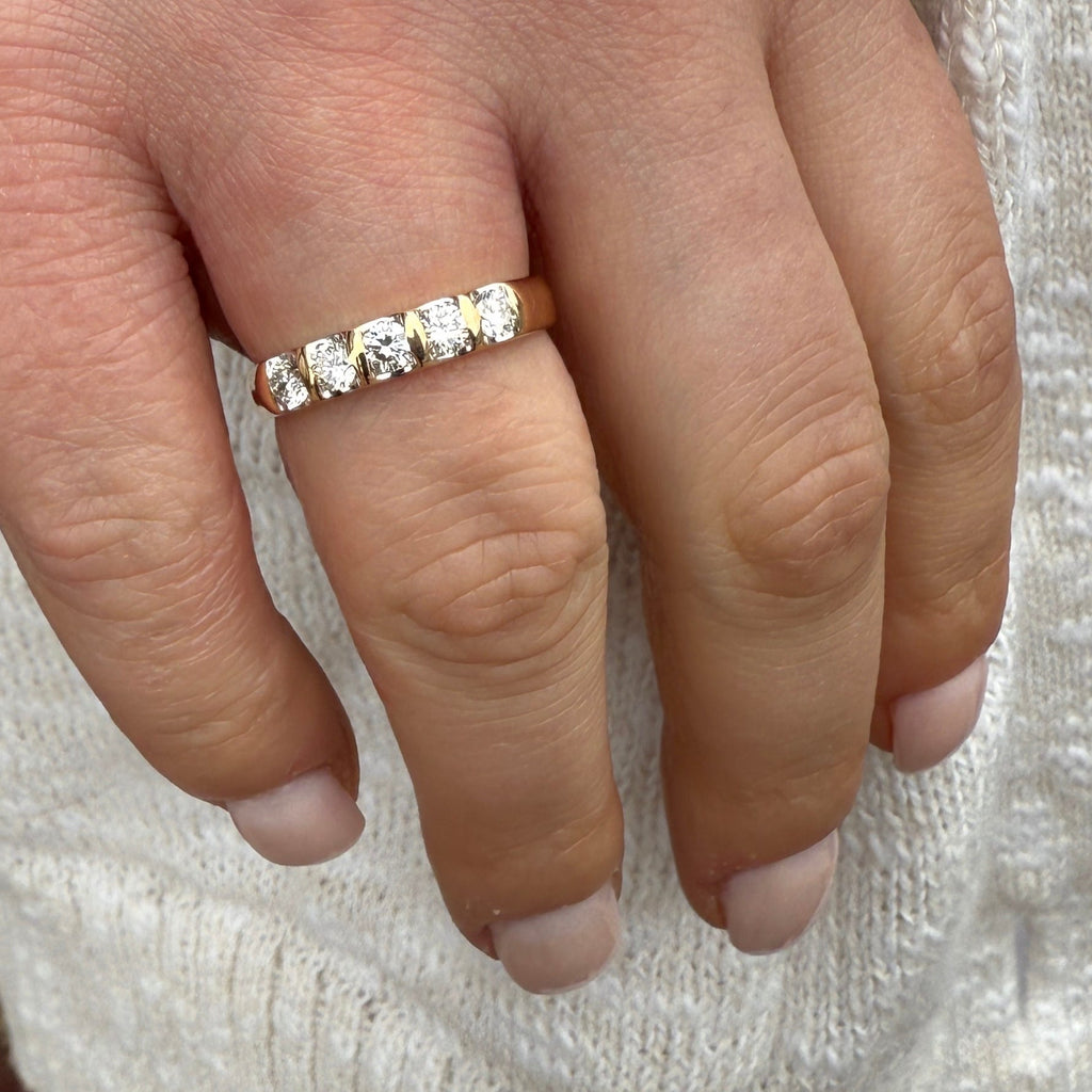 Close-up of a hand wearing a diamond ring on a textured white background