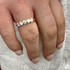 Close-up of a hand wearing a diamond ring on a textured white background
