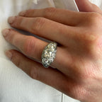 Close-up of a hand wearing a decorative ring on a white background