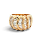 A gold ring featuring five interlocking curved bands, each lined with clear baguette-cut stones, shown on a white background with a soft shadow.